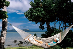 Man relaxing in a hammock in a quiet environment.